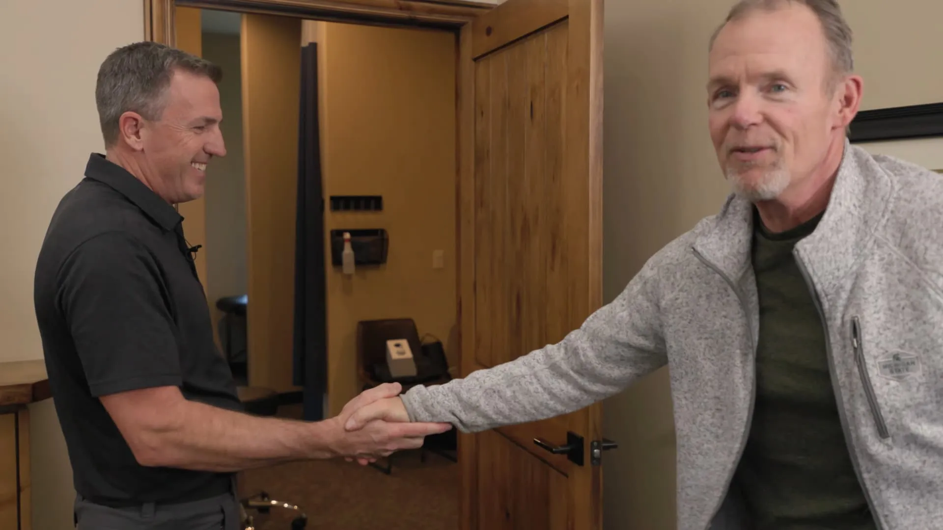 Chiropractor greeting patient at clinic