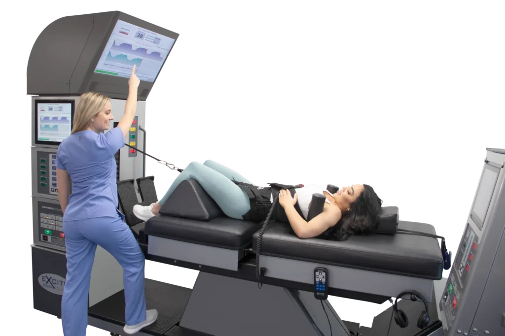 Female chiropractic assistant educating her patient about the DRX 9000 spinal decompression machine screen