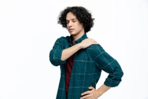 Man standing and holding shoulder due to rotator cuff pain