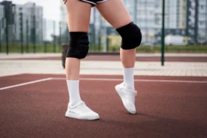 Athlete holding knee in pain from jumper’s knee injury