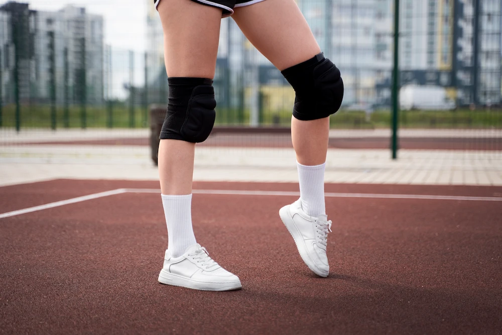 Athlete holding knee in pain from jumper’s knee injury